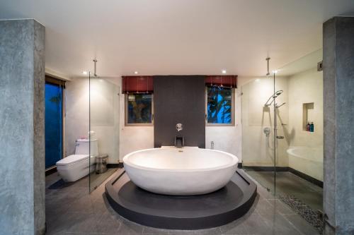 a large white tub in a bathroom with a toilet at Bang Tao 6-bedroom large private pool modern Balinese style leisure holiday villa BBQ family group the park in Laguna Phuket