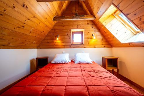 a bedroom with a large red bed in a attic at La grange in Les Salces