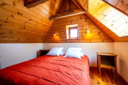 a bedroom with a red bed in a wooden attic at La grange in Les Salces