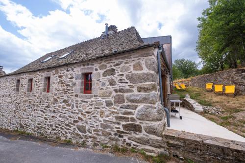 an old stone building with a red window at La grange in Les Salces