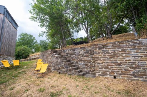 a group of yellow chairs sitting next to a brick wall at La grange in Les Salces