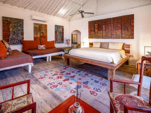 una camera da letto con un letto, un divano e un tavolo di Villa Pasir a Nusa Lembongan