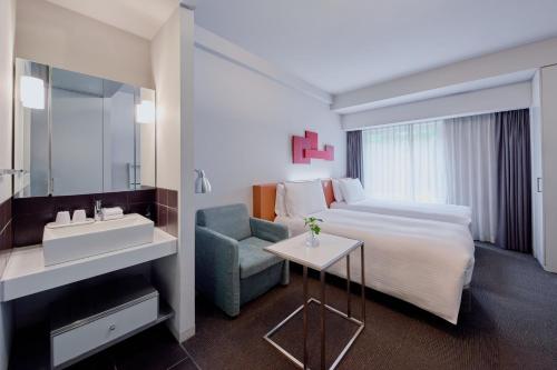 a hotel room with a bed and a sink at Citadines Shinjuku Tokyo in Tokyo