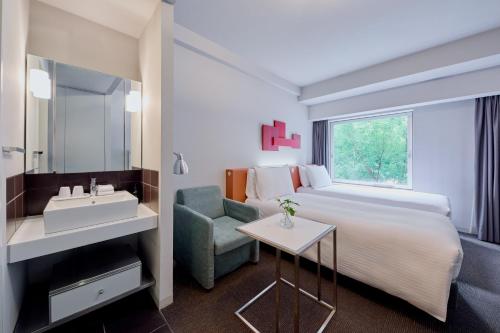 a hotel room with a bed and a sink at Citadines Shinjuku Tokyo in Tokyo