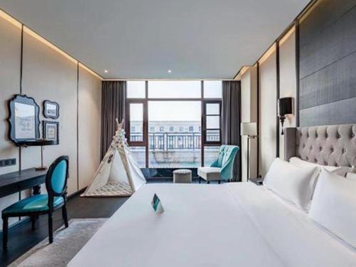 a hotel room with a large bed and a desk at Xana Hotelle Luzhou High-Speed Railway Station Trading Market Passenger Terminal in Luzhou