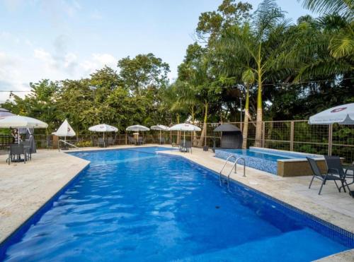 una piscina con sedie e ombrelloni in un resort di Elegante apartamento con Golf, Restaurantes y Spa a ArraijÃ¡n
