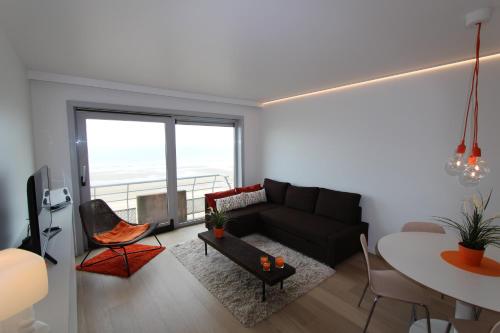 a living room with a couch and a table at Studio Zeezicht in Ostend