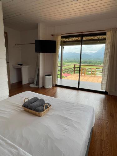 a bedroom with a bed with a view of a balcony at PATTA Hideaway Chiang Dao in Chiang Dao