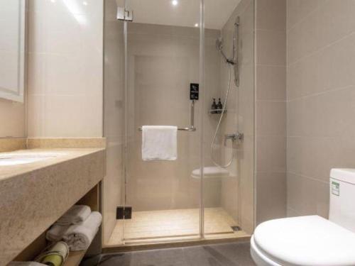 a bathroom with a shower with a toilet and a sink at City Comfort Inn Shiyan Wudang Mountain in Danjiangkou