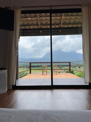 a room with a large window with a view of the ocean at PATTA Hideaway Chiang Dao in Chiang Dao