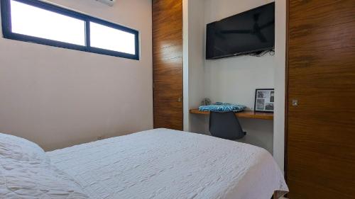 una camera da letto con un letto, una finestra e una televisione di Cozy studio steps from the beach and downtown a Puerto Vallarta