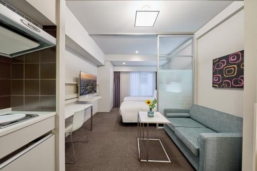 a hotel room with a bed and a couch at Citadines Shinjuku Tokyo in Tokyo