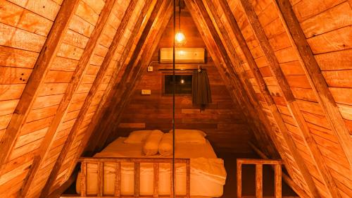 a bedroom in a wooden cabin with a bed at House of Bima in Gianyar