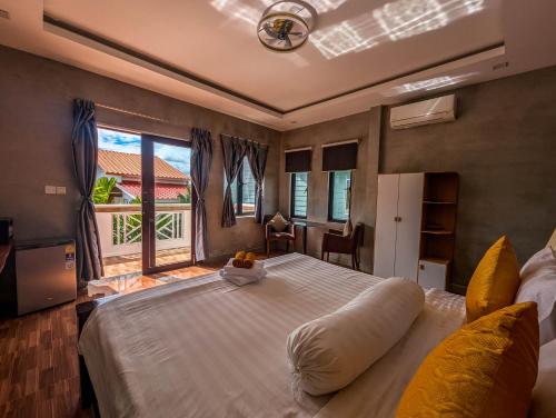 a bedroom with a large bed with a large window at Travellers Inn in Phumĭ Réach Born