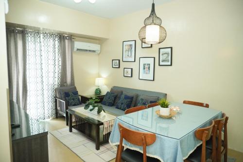 a living room with a table and a couch at Cozy 2 Bedroom Condo with Balcony for Rent in Iloilo City