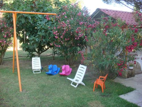 a group of lawn chairs sitting in the grass at Villa Angela in Sikia