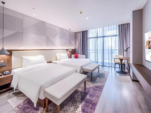 une chambre d'hôtel avec deux lits et une télévision dans l'établissement Borrman Hotel Chongzuo Guangxi Normal University for Nationalities, à Buli