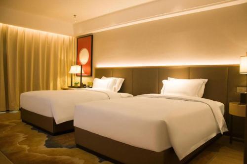 Ένα ή περισσότερα κρεβάτια σε δωμάτιο στο Echeng Hotel Enshi Minzu Road