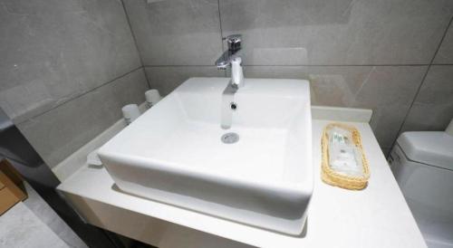 a bathroom with a white sink and a toilet at Green Tree Inn Urumqi San'gong Metro Station Exit in Ürümqi