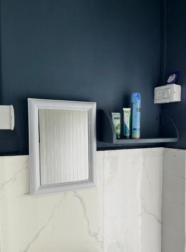 a white mirror on a shelf in a bathroom at Yellow Stay in Āīzawl