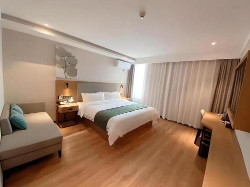 a hotel room with a bed and a chair at Green Tree Inn Luoyang Fenghuang Mansion Mudan Square Metro Station in Luoyang