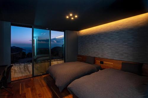 a bedroom with two beds and a large window at Awaji-shima C-Side Hill Top Terrace - Vacation STAY 88185v in Minamiawaji