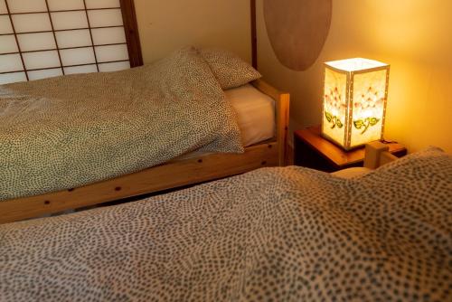 a bedroom with two beds and a lamp on a table at Hide A Way - Vacation STAY 90104v in Nishinoomote