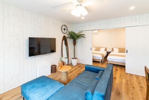 a living room with a blue couch and a tv at Grandioso Okinawa Villa Kin 2 - Vacation STAY 24799v in Yaka