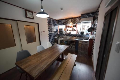 a kitchen with a wooden table and chairs in it at Hostel Knot - Vacation STAY 88773v in Izu