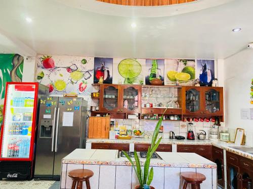 a kitchen with a refrigerator and a counter with stools at Sarisa House in Iquitos