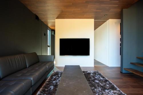 a living room with a couch and a flat screen tv at Awaji-shima C-Side Dual View - Vacation STAY 88182v in Minamiawaji