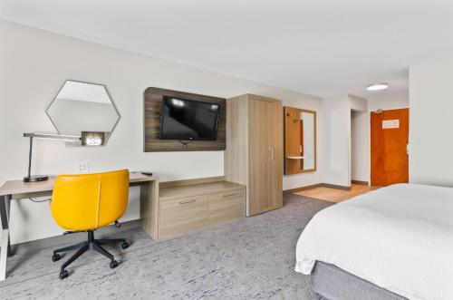 a hotel room with a bed and a desk and a television at Holiday Inn Express Hotel & Suites Mount Airy by IHG in Mount Airy