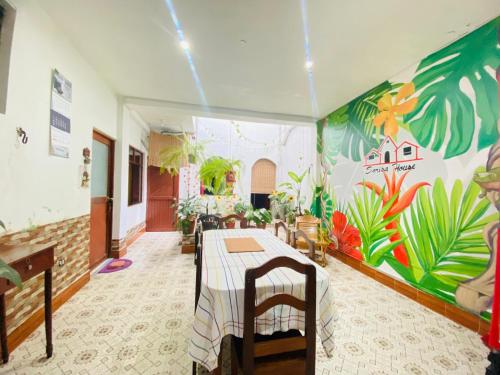 a dining room with a table and a mural at Sarisa House in Iquitos