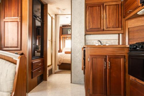 a kitchen with wooden cabinets and a bed in a room at MUUN Beach Club in Ciudad del Carmen