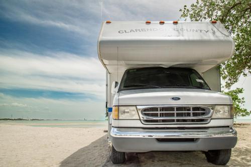 a white truck parked on the beach at MUUN Beach Club in Ciudad del Carmen