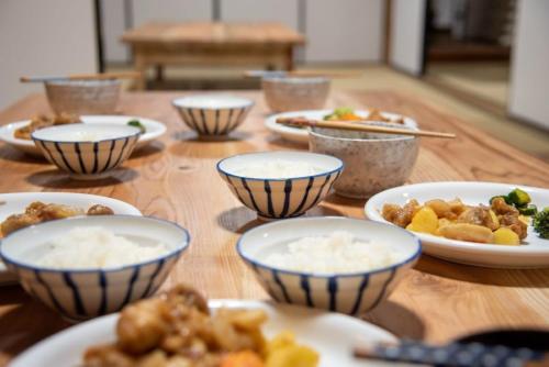 a wooden table with bowls of food on it at Worcation base Kaminyu Yamane House - Vacation STAY 03960v in Nagahama