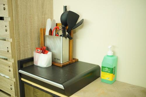 a counter with a container of utensils and a bottle of cleaner at Cozy 2 Bedroom Condo with Balcony for Rent in Iloilo City