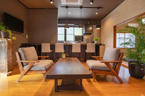 ein Wohnzimmer mit Tisch und Stühlen und eine Küche in der Unterkunft guesthouse UZU Sado - Vacation STAY 90684v in Sado