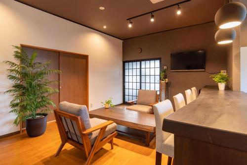 a living room with a wooden table and chairs at guesthouse UZU Sado - Vacation STAY 01114v in Sado