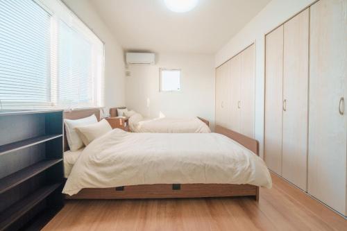 a bedroom with two beds and a large window at Ryushima Ocean View Besso - Vacation STAY 13427 in Minamiboso