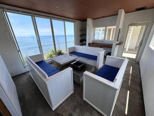 a living room with chairs and a table and windows at SunSet Villa - Vacation STAY 52994v in Nagaoka