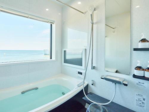 淡路市にあるT,square - Vacation STAY 30959vの浴槽と窓のある白いバスルーム