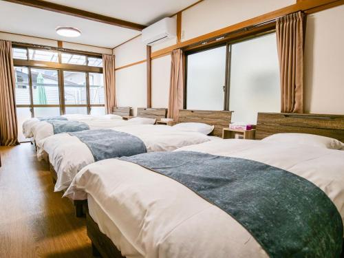 a row of beds in a room with windows at Family Villa KASAMA - Vacation STAY 42429v in Kasama
