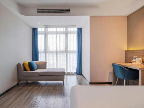 a living room with a couch and a window at 7 Days Premium Hotel Chongqing Jiangbei International Airport Terminal 3 in Chongqing