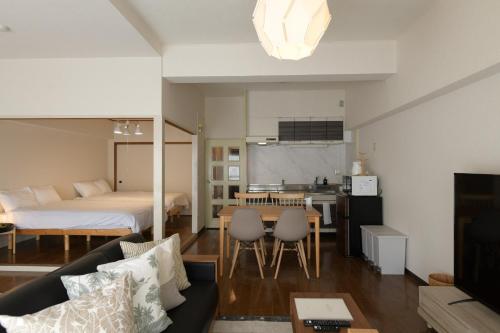 a living room and kitchen with a bed and a table at RIVER WEST Hiroshima 302, 305, 306 - Vacation STAY 54102v in Ōsukachō