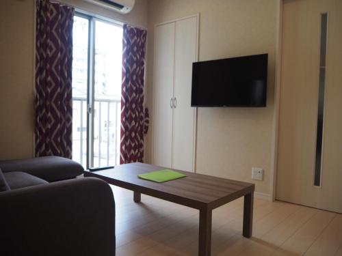 a living room with a couch and a coffee table at Harbor City Terrace 202 - Vacation STAY 13565 in Higashi-horidōri