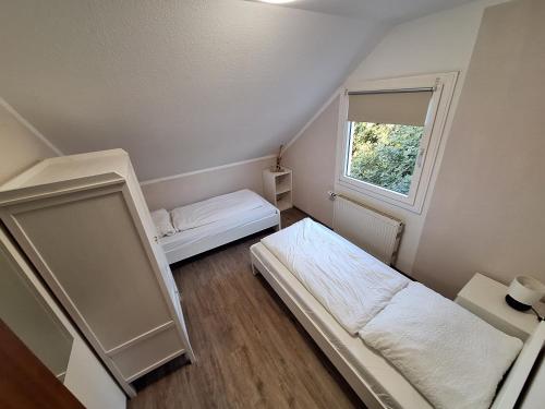 a small room with two beds and a window at Elbidylle Ferienwohnung in Barby am Elberadweg in Barby