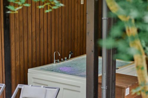a bathroom with a tub with a sink at SAUNA FOREST CABIN Karuizawa Miyota - Vacation STAY 23176v in Oiwake