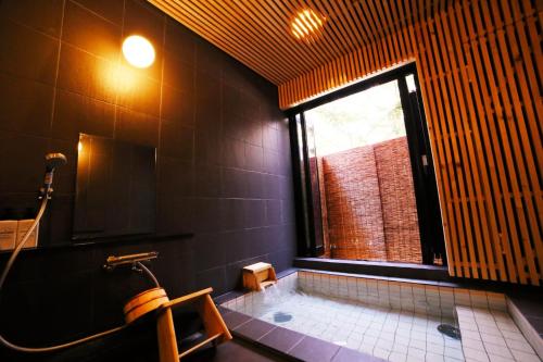 a bathroom with a tub and a window at Chillps - Vacation STAY 77708v in Iida