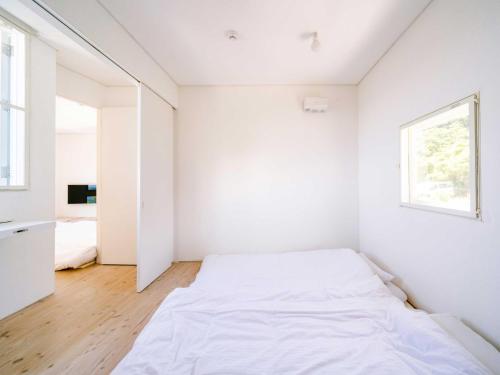 a white bedroom with a bed and a window at NE-2930 - Vacation STAY 68092v in Awaji